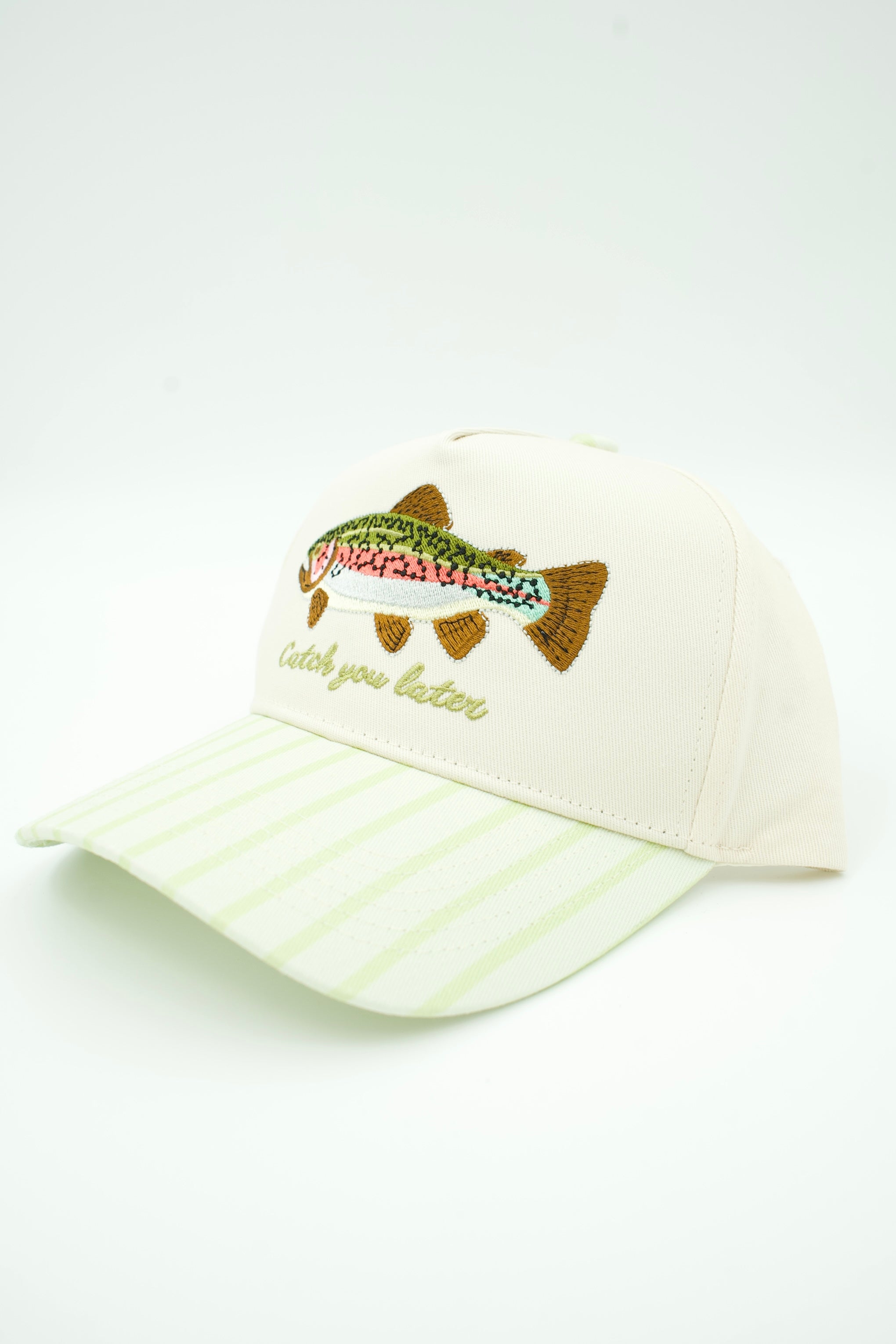 An off-white baseball cap with a light green striped brim, featuring an embroidered rainbow trout and the phrase 'catch you later' on the front.