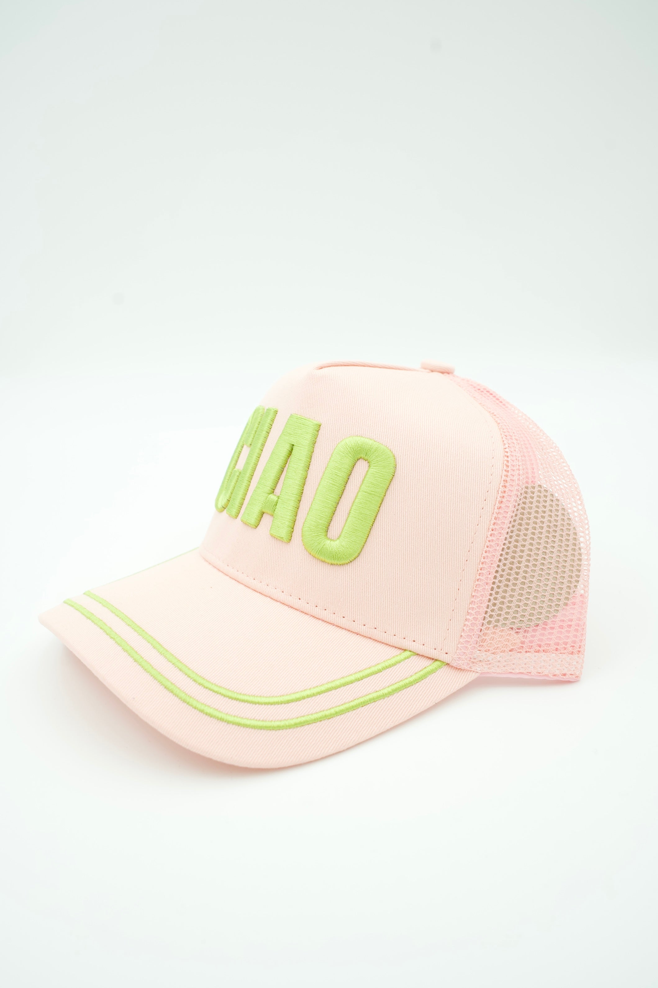 A light pink trucker-style baseball cap with lime green embroidered lettering on the front and matching lime green piping along the brim, shown on a plain white background.