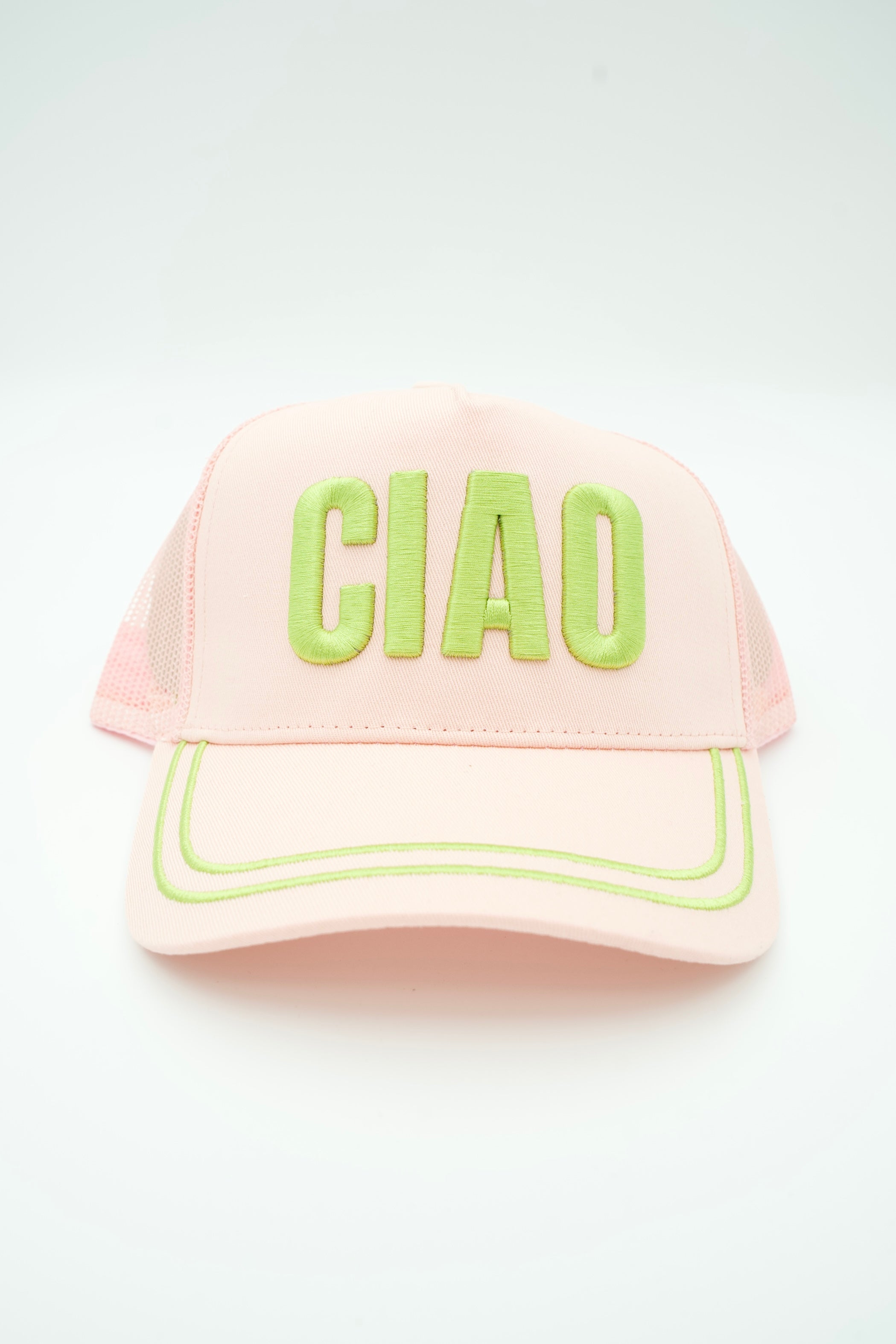 A light pink trucker-style cap with 'CIAO' embroidered in bright lime green on the front, set against a plain white background.