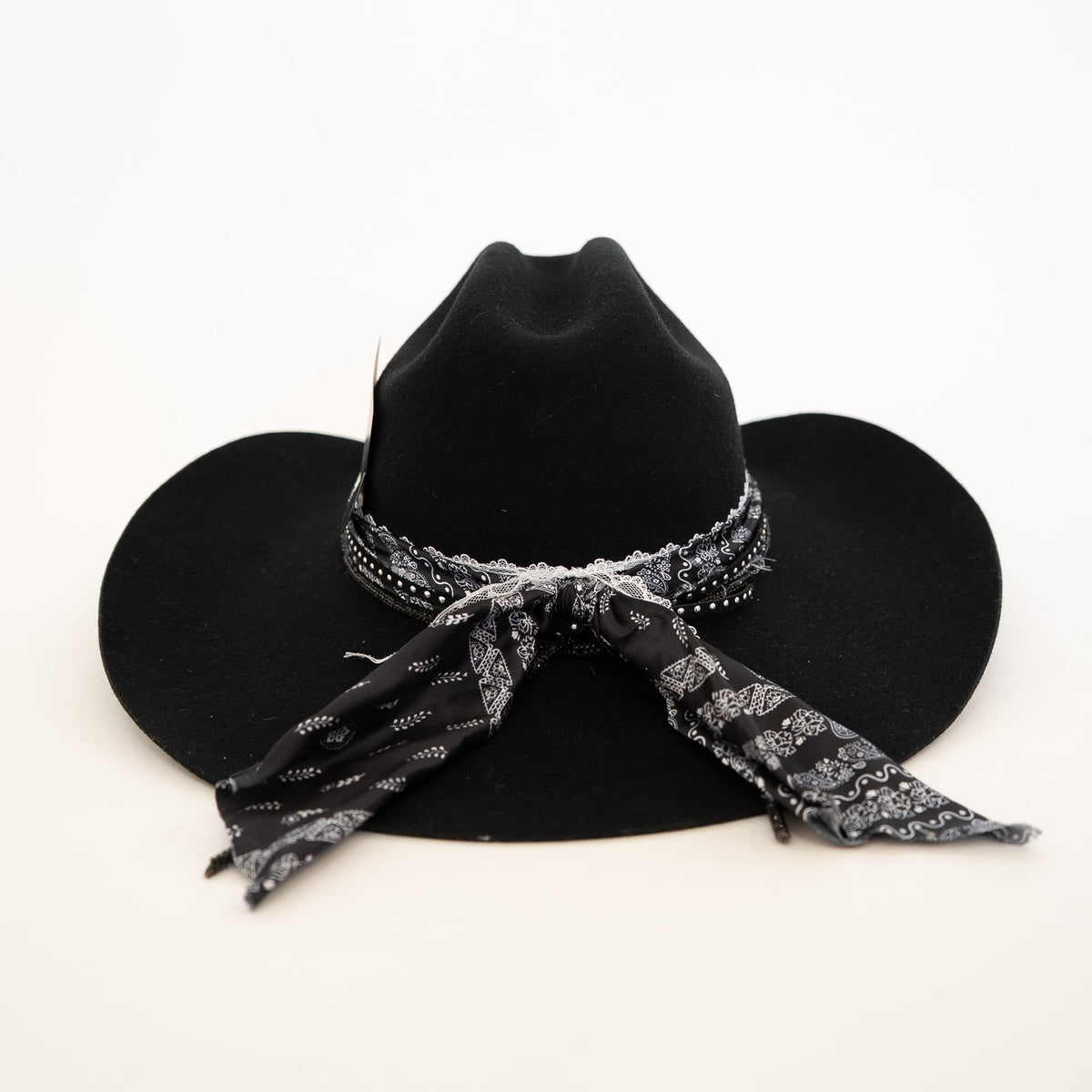 Black cowboy hat with a patterned bandana on a white background