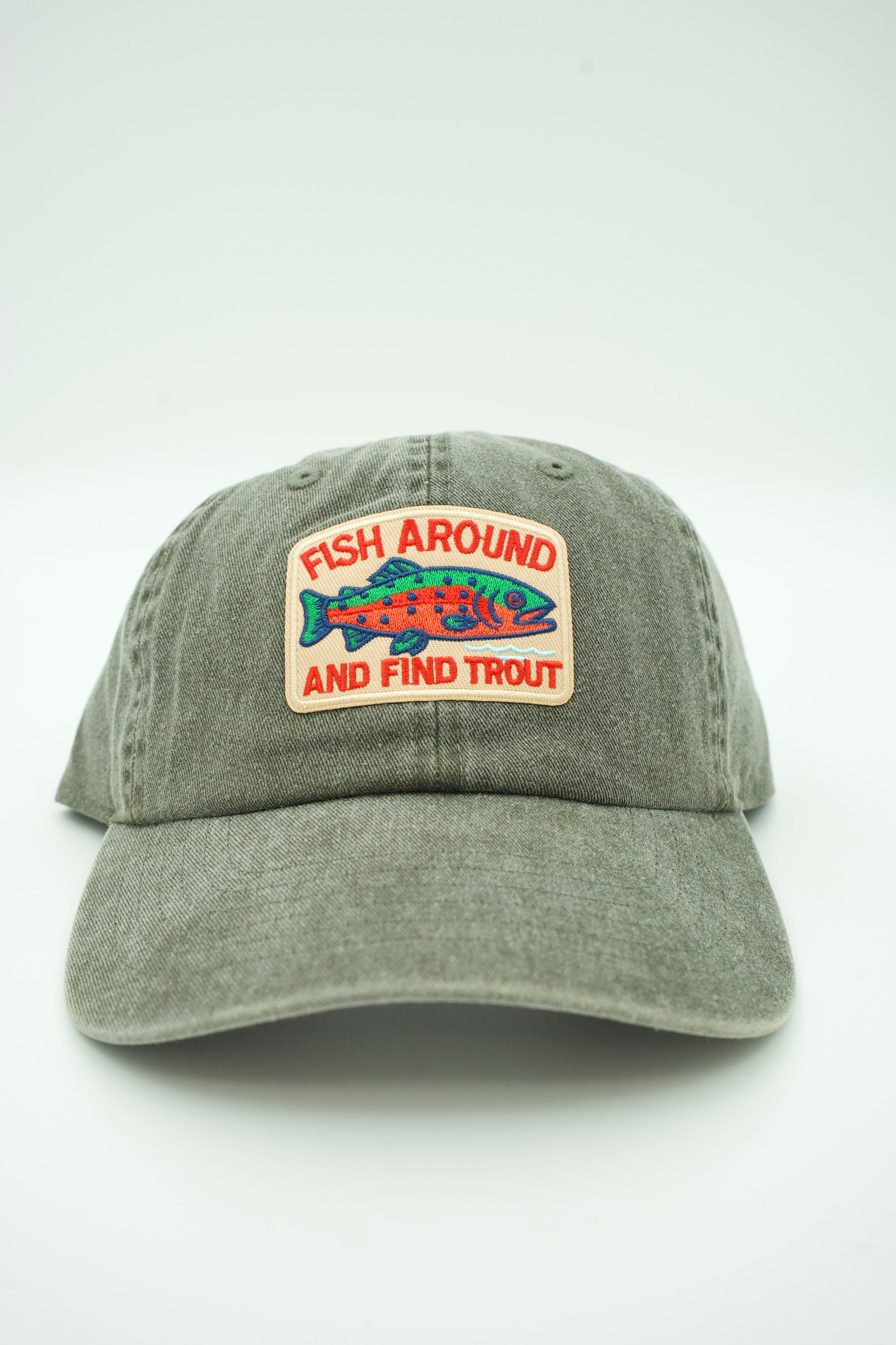 A washed grey baseball cap featuring a front patch with a colorful fish and the text 'FISH AROUND AND FIND TROUT'.
