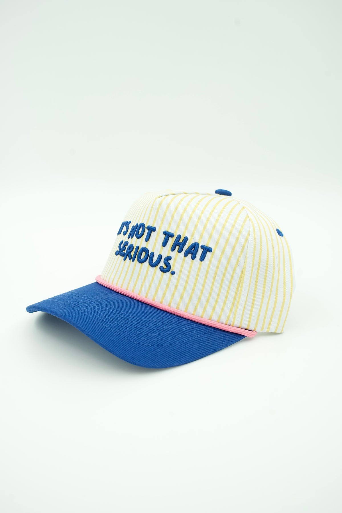 Side image of yellow striped trucker hat with IT'S NOT THAT SERIOUS embroidered on it and a blue bill