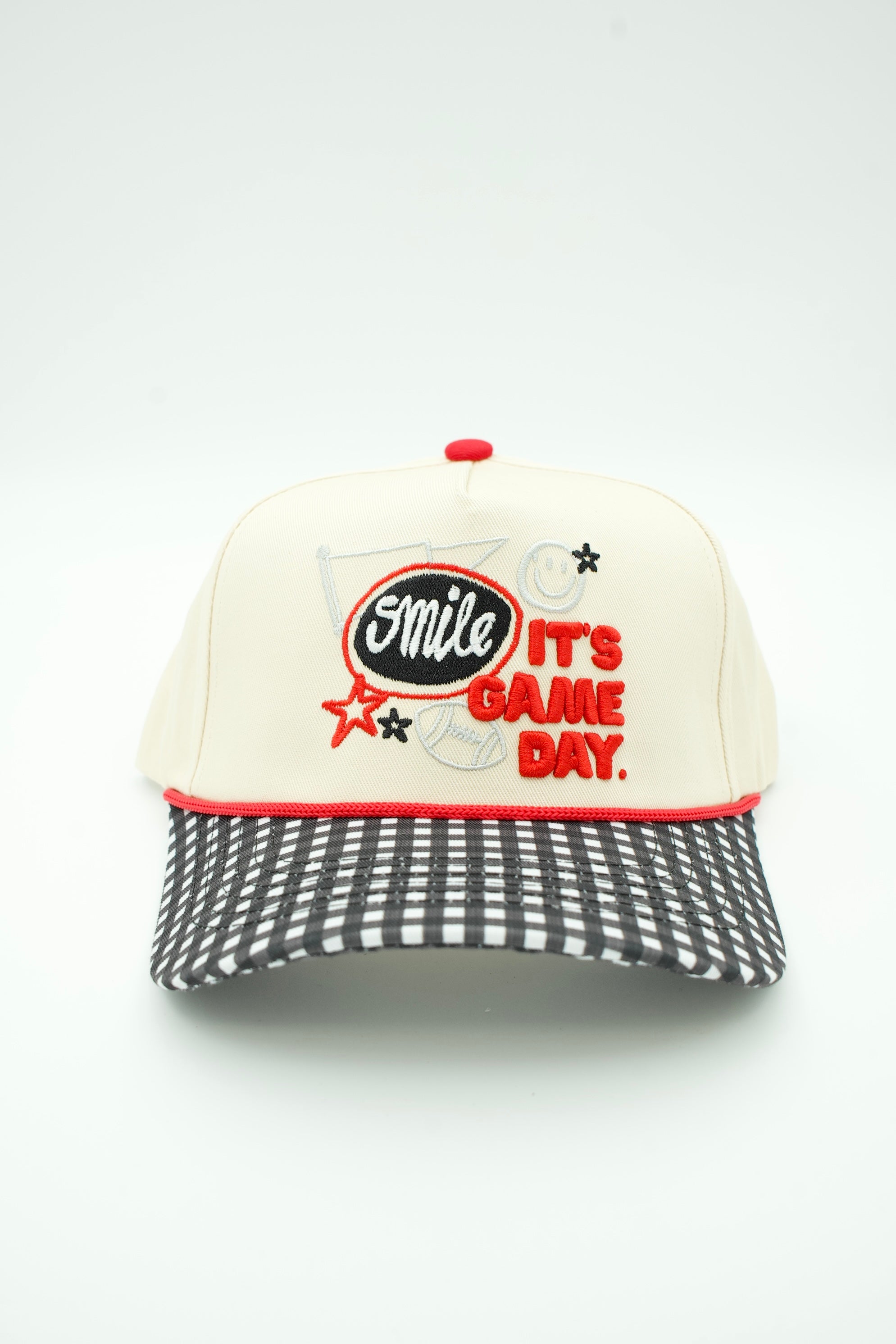 A baseball cap with an off-white crown, red button and trim, and a black-and-white checkered visor. The front features embroidered text reading 'Smile IT'S GAME DAY.