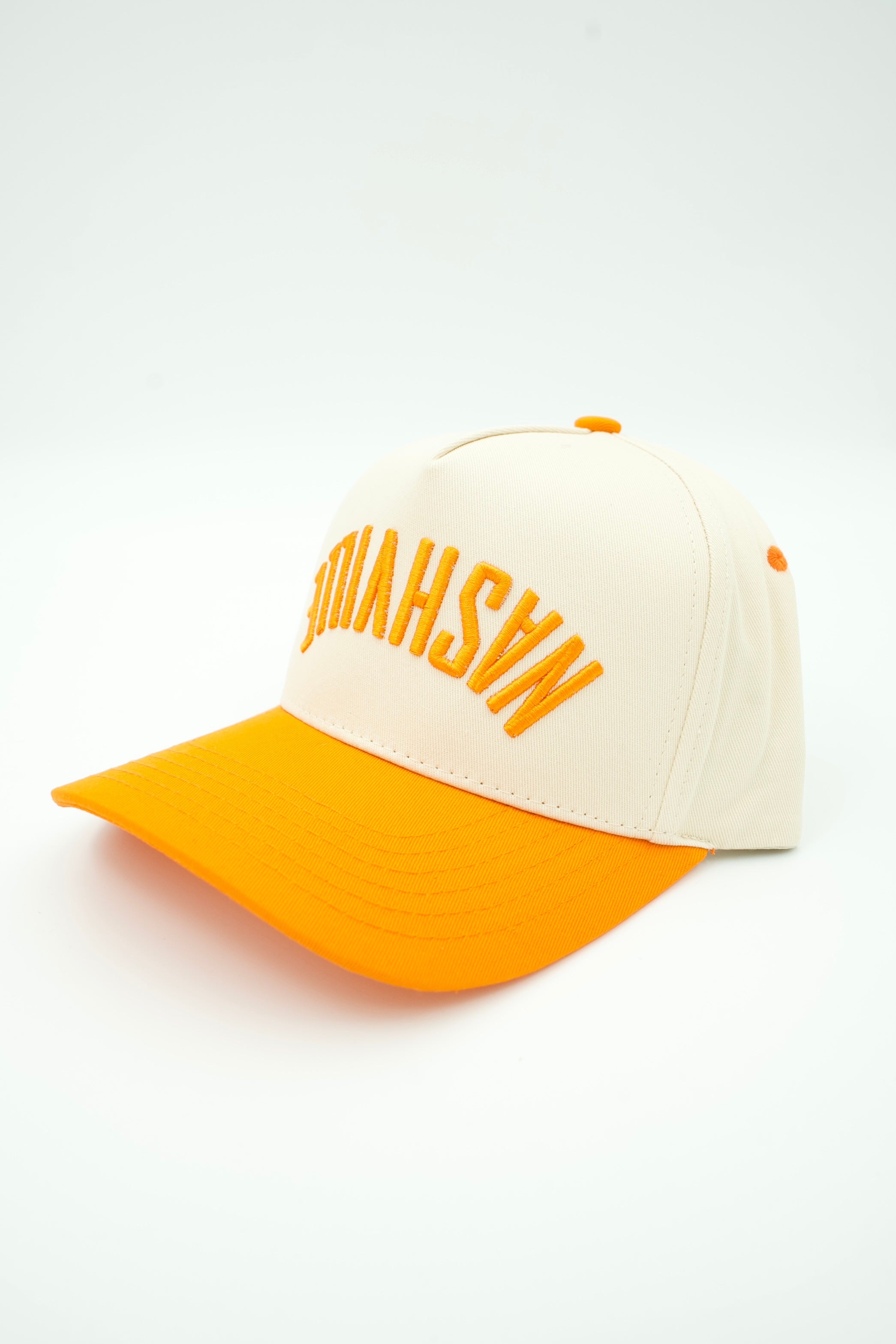 A baseball cap with an off-white crown and a bright orange visor, featuring the word 'NASHVILLE' embroidered in orange across the front panels.