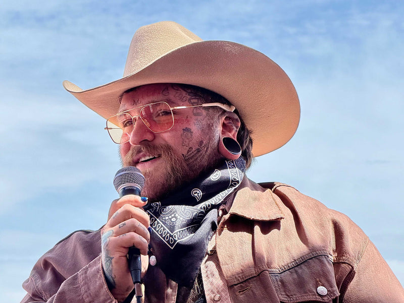 Image of Teddy Swims in a Cowboy Hat Singing into a Mic