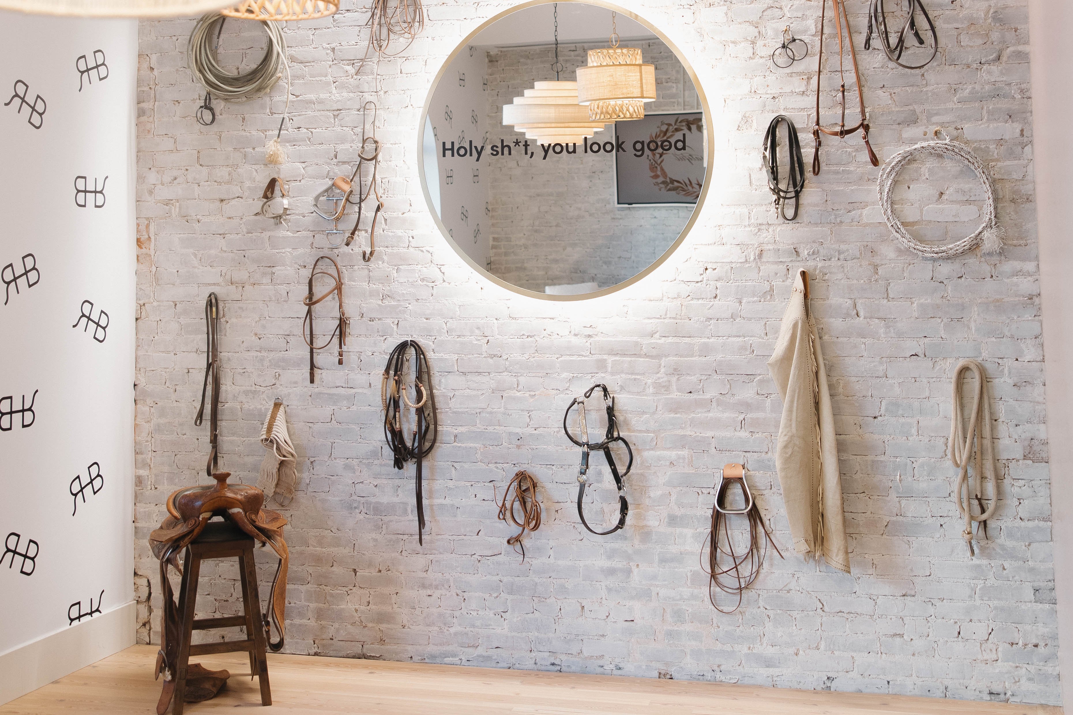 Decorative wall with hanging items and a chandelier in a room.