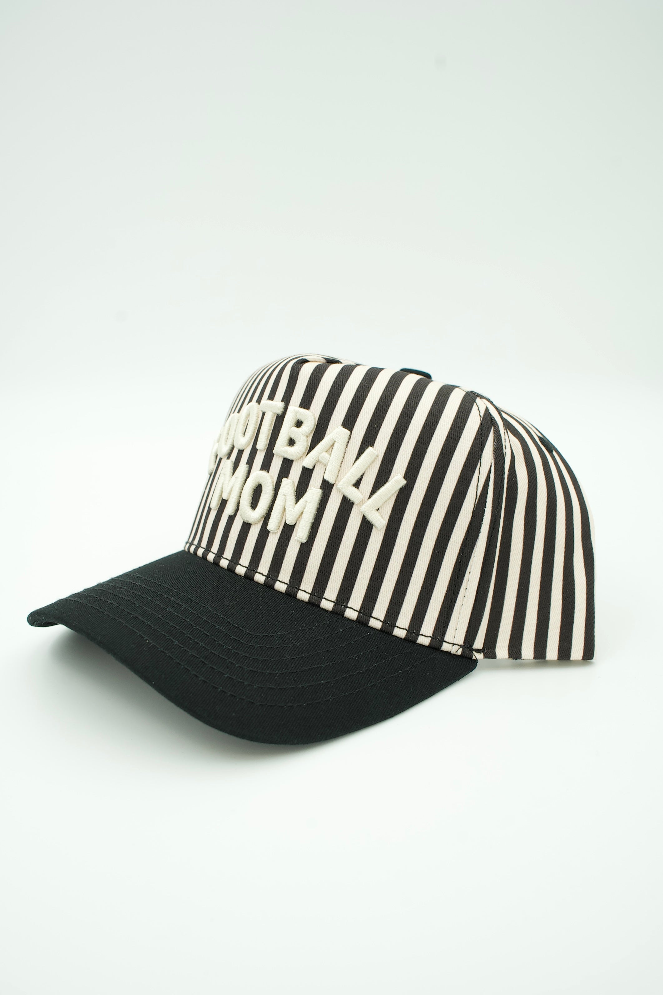 A baseball cap with a black curved brim and a black-and-white vertically striped crown, featuring the text 'FOOTBALL MOM' embroidered in white on the front.