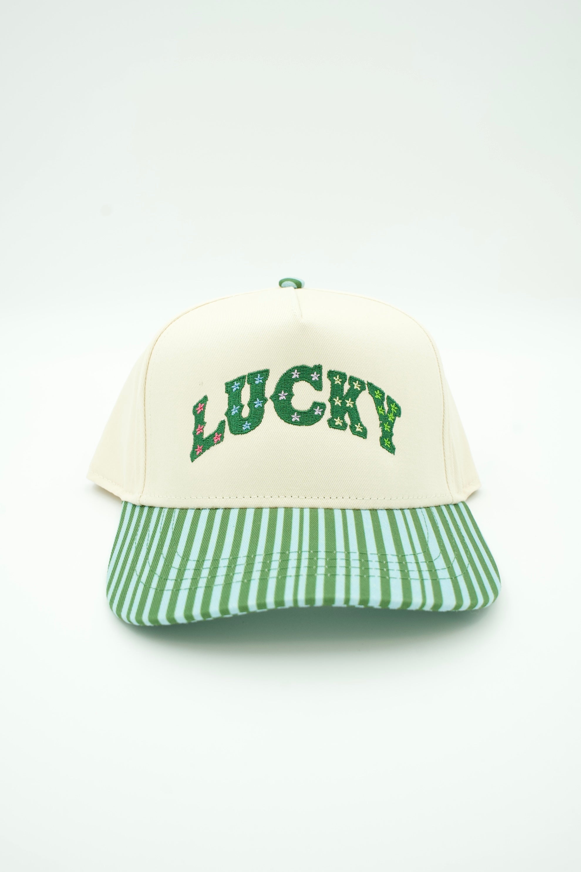 A baseball cap with an off-white crown and a green and white striped visor, featuring the word 'LUCKY' embroidered in green across the front.