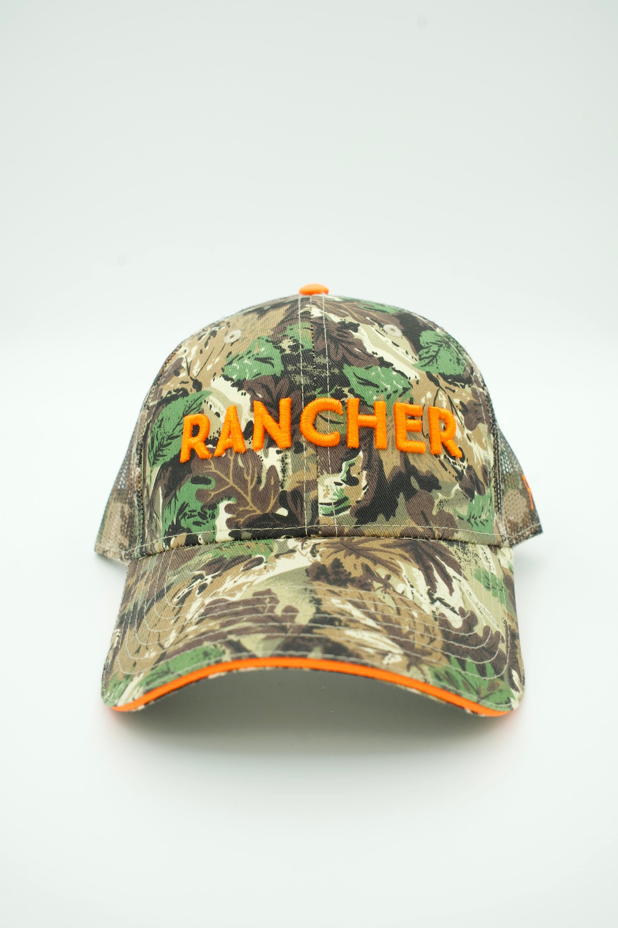 A camouflage baseball cap with 'RANCHER' embroidered in bright orange across the front, set against a plain light gray background.