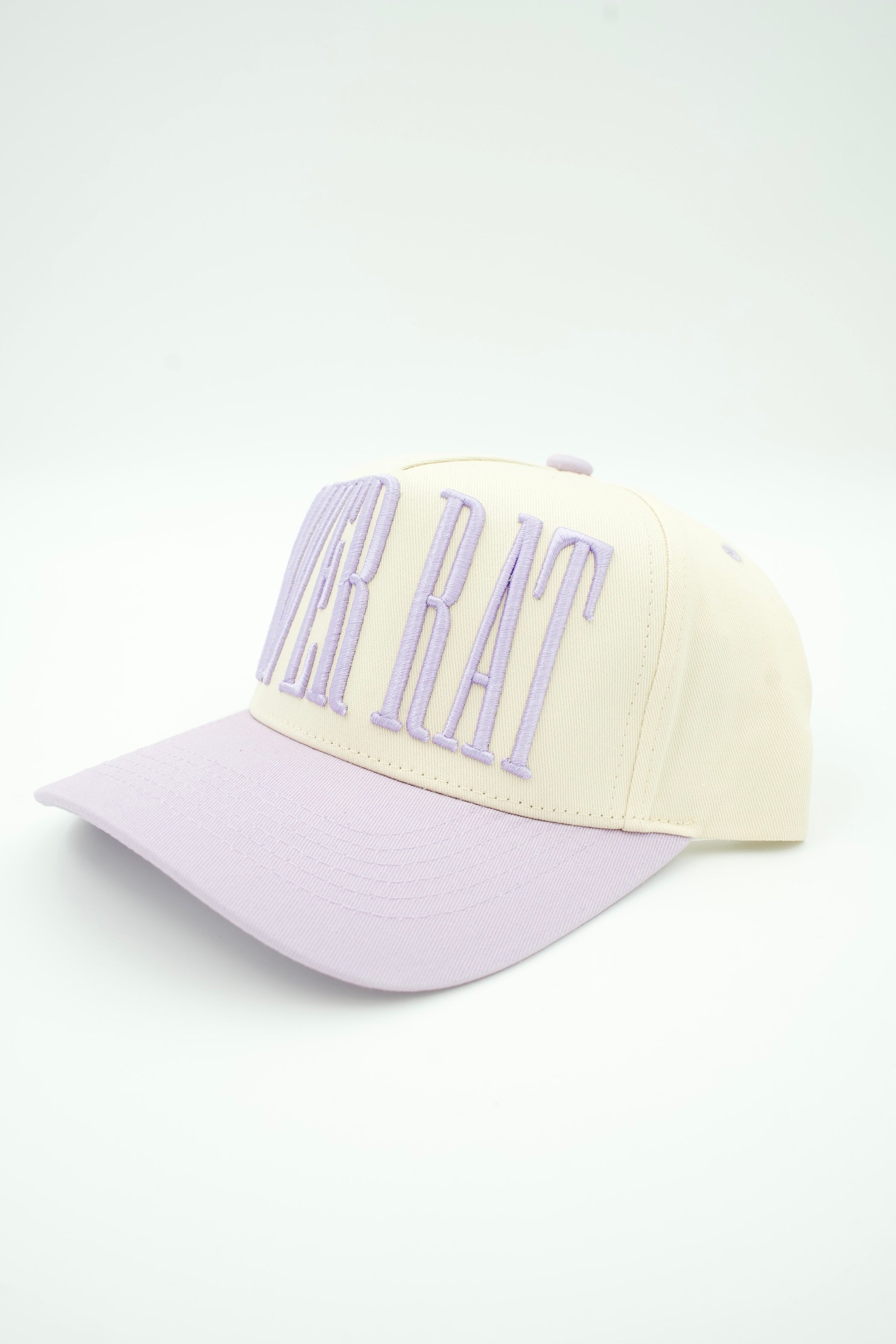 A baseball cap with a cream crown and a light purple brim, featuring the words 'POWER RAT' embroidered in light purple on the front.