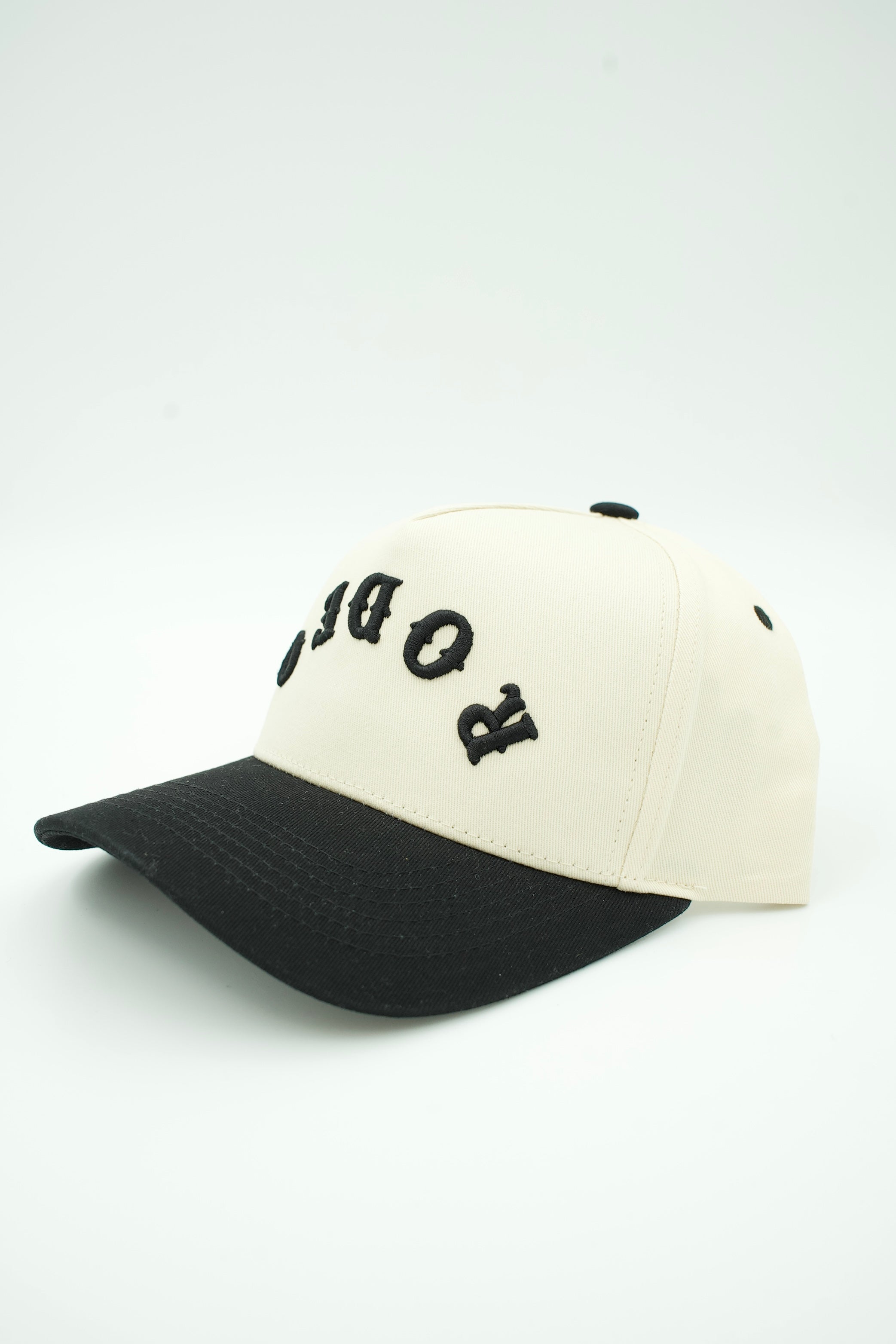 A baseball cap with an off-white crown and a black curved brim, featuring black embroidered letters spelling 'ROBOMAN' on the front.